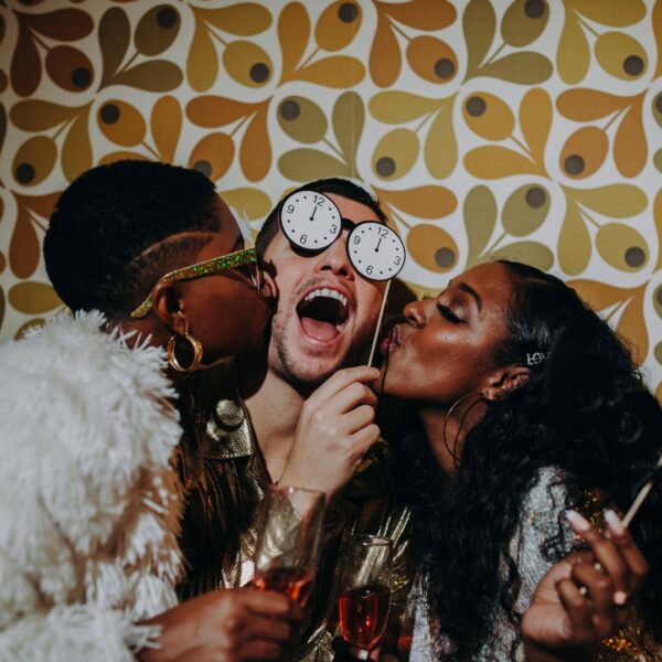 three friends having fun in a photobooth